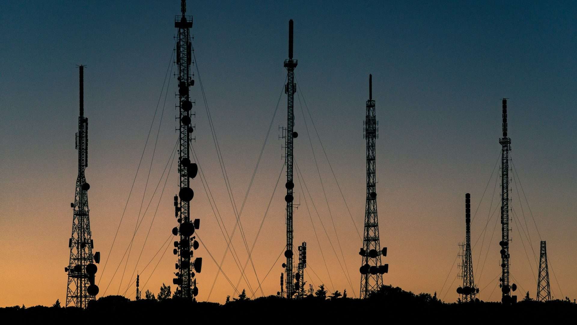 Telecommunication towers at sunset representing connectivity and mobile network infrastructure.